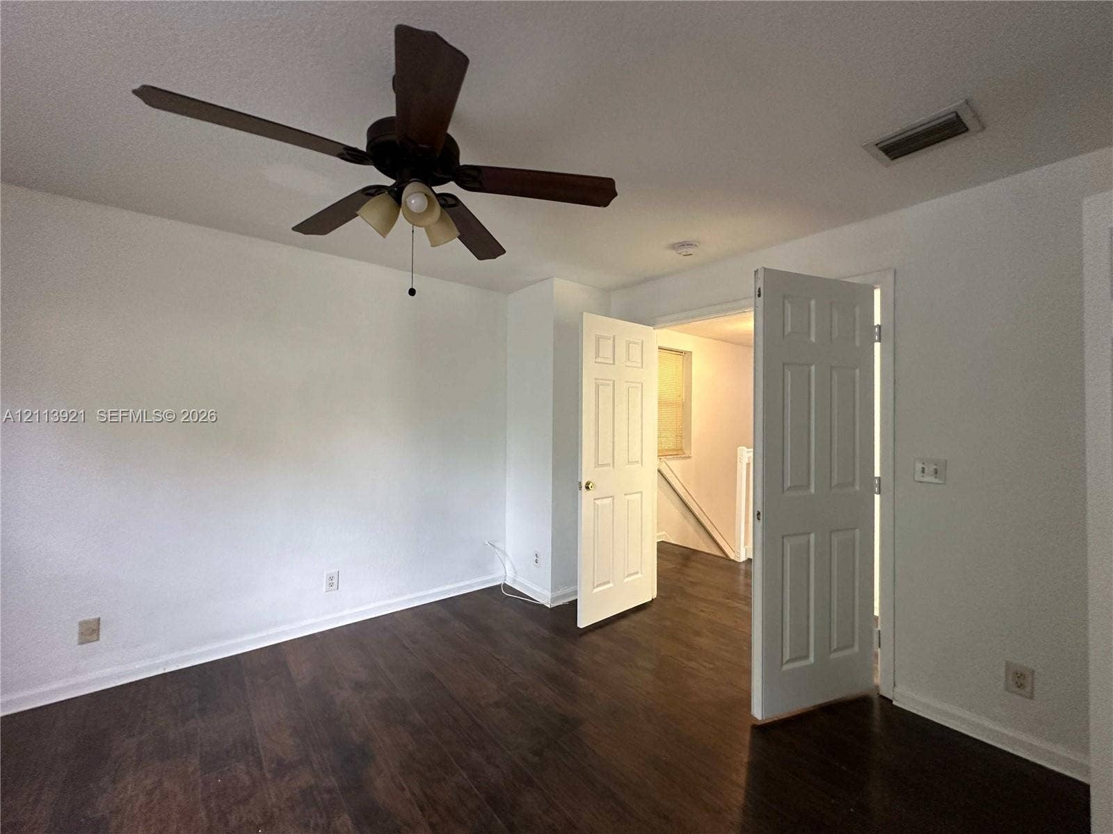 824 Summit Lake Drive, West Palm Beach, West Palm Beach, FL 33406 Room featuring wood-finish flooring, a six-panel door, and a ceiling fan with integrated lighting