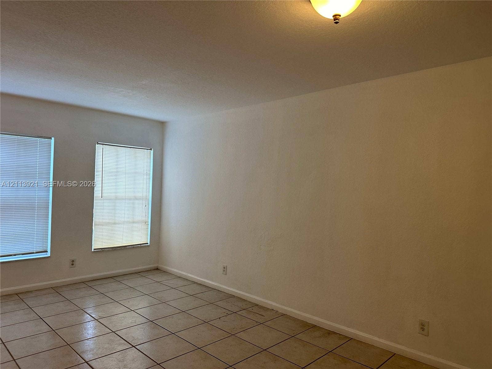 824 Summit Lake Drive, West Palm Beach, West Palm Beach, FL 33406 Neutral-toned ceramic tile flooring, two windows with horizontal blinds, and a dome-style flush-mount ceiling light