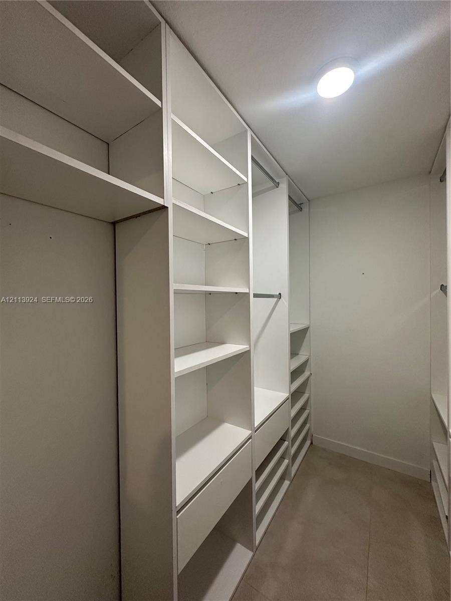 14569 SW 261st Terrace, #14569, Homestead, Homestead, FL 33032 Custom built-in closet organization system featuring white shelving, integrated drawers, and metal hanging rods