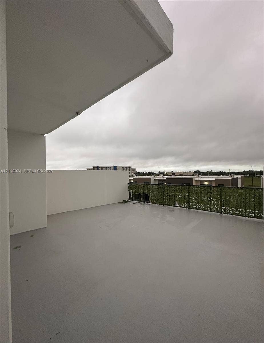 14569 SW 261st Terrace, #14569, Homestead, Homestead, FL 33032 Covered balcony featuring smooth-surface flooring, high solid-panel perimeter walls, and a decorative screen railing