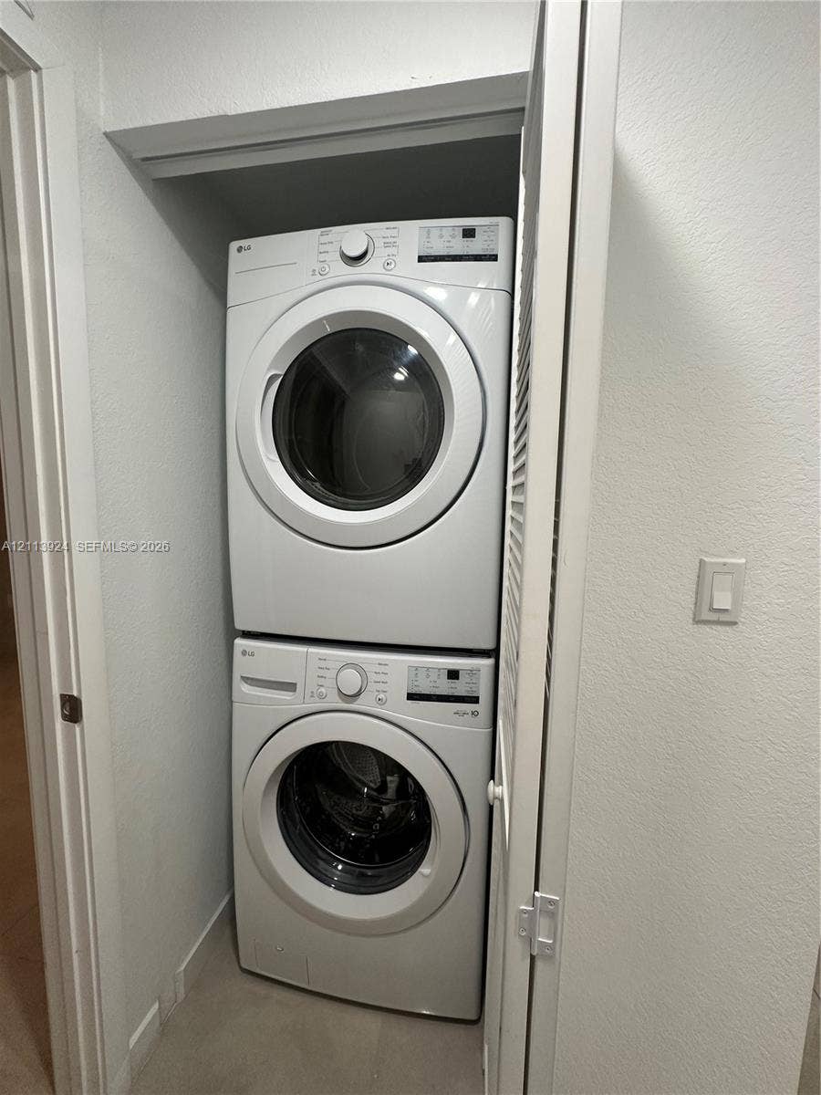 14569 SW 261st Terrace, #14569, Homestead, Homestead, FL 33032 Stacked washer and dryer unit housed within a dedicated closet featuring a louvered door