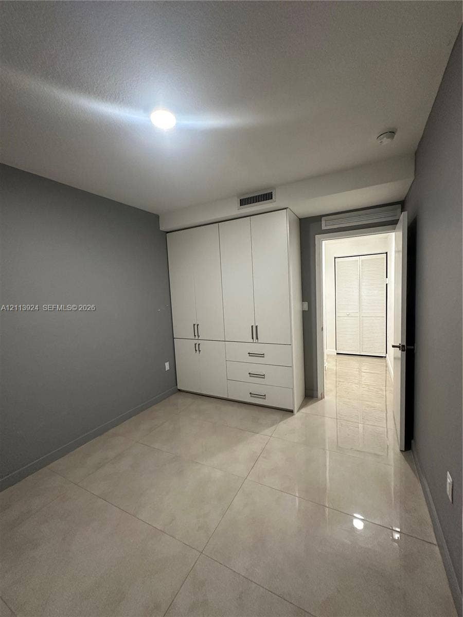 14569 SW 261st Terrace, #14569, Homestead, Homestead, FL 33032 Large-format tile flooring, built-in floor-to-ceiling white cabinetry with integrated drawer storage, and neutral wall tones