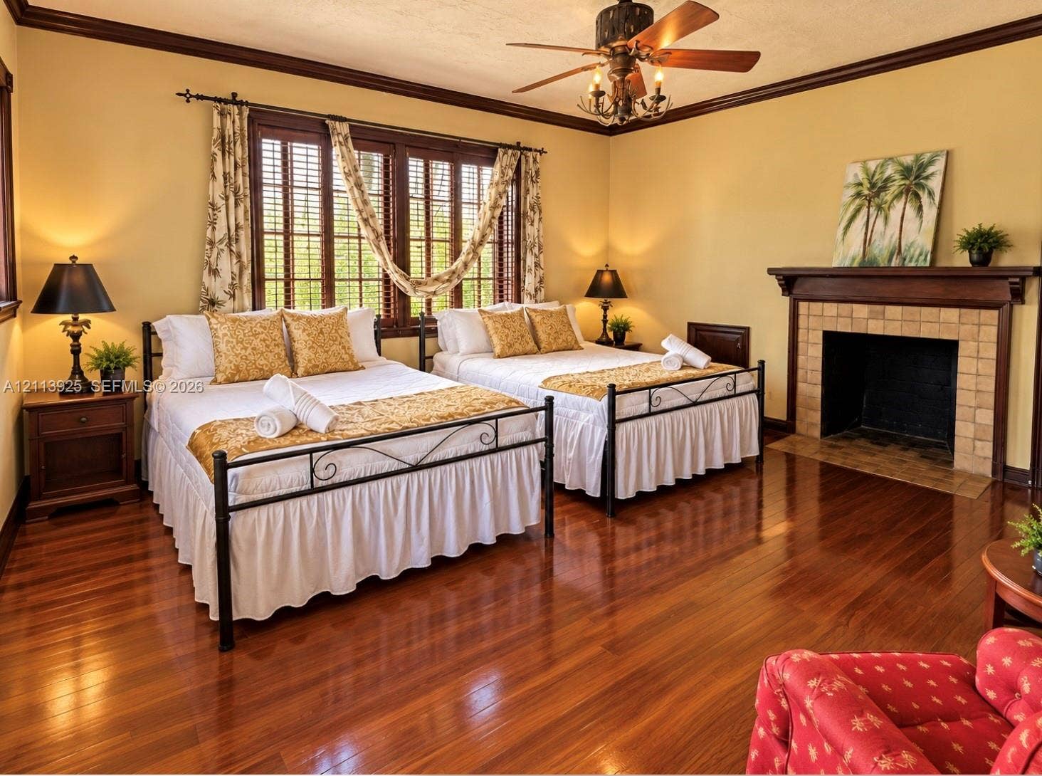 1055 Hollywood Boulevard, Hollywood, Hollywood, FL 33019 Wood-finish flooring, fireplace with a tile surround and wood mantel, multi-pane windows with louvered shutters, crown molding, and a ceiling fan with integrated lighting