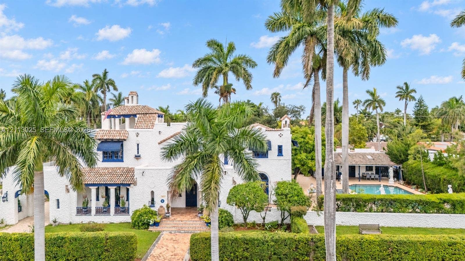 1055 Hollywood Boulevard, Hollywood, Hollywood, FL 33019 Mediterranean-style estate featuring a textured stucco exterior, clay tile roof, covered loggia, swimming pool, and gated entrance
