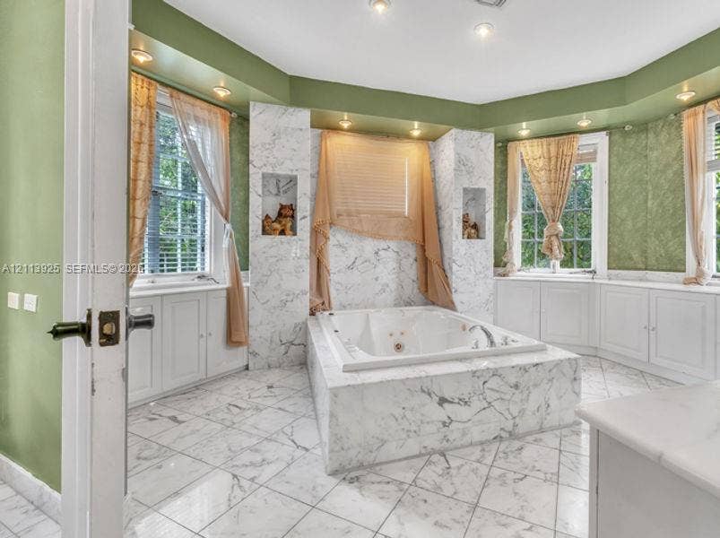 1055 Hollywood Boulevard, Hollywood, Hollywood, FL 33019 Stone-surround jetted soaking tub, custom stone flooring, built-in shelving niches, recessed lighting, and expansive wrap-around cabinetry