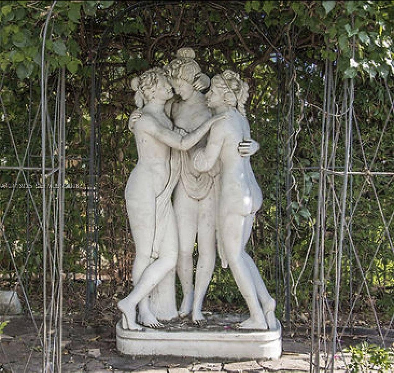 1055 Hollywood Boulevard, Hollywood, Hollywood, FL 33019 Ornate stone figurative sculpture positioned beneath a metal garden trellis