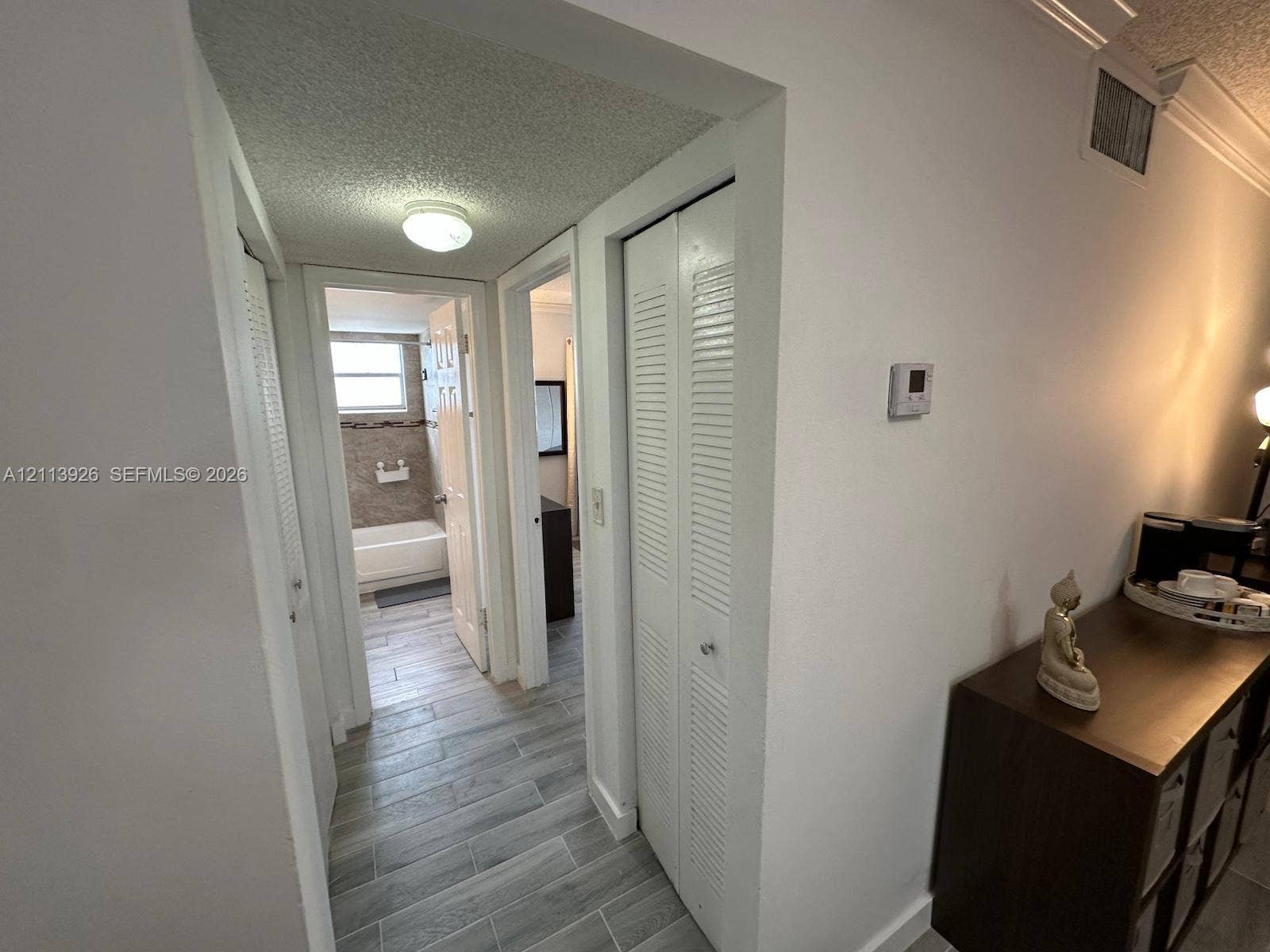 2008 Jackson Street, #D3, Hollywood, FL 33020 Hallway featuring wood-finish tile flooring, multiple louvered-door closets, and crown molding