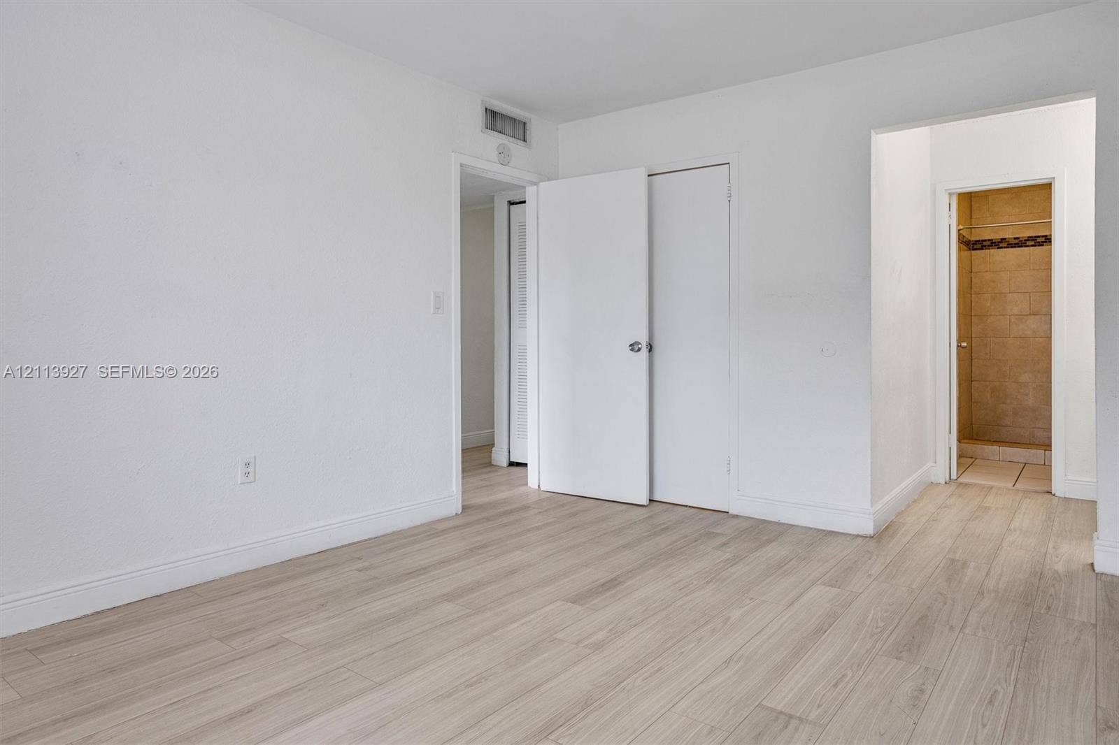 4900 NW 79th Avenue, #202, Doral, Doral, FL 33166 Interior space featuring wood-finish flooring, white walls, and interior swinging doors