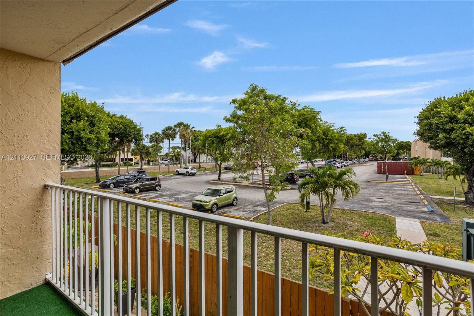 4900 NW 79th Avenue, #202, Doral, Doral, FL 33166 Outdoor balcony featuring a vertical metal railing and wood-finish privacy screening