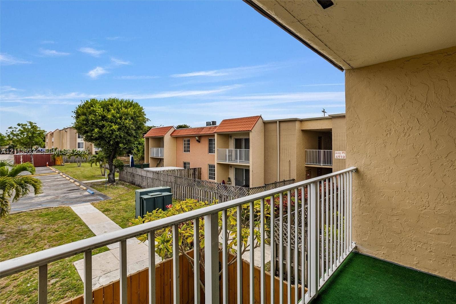 4900 NW 79th Avenue, #202, Doral, Doral, FL 33166 Covered balcony featuring white metal railings and green floor surfacing