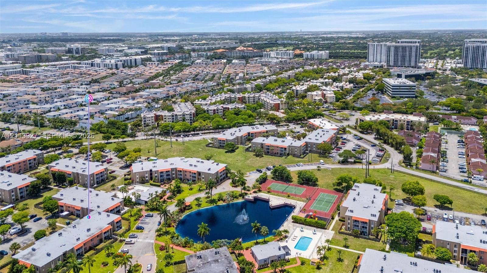4900 NW 79th Avenue, #202, Doral, Doral, FL 33166 Aerial perspective of a multi-unit complex featuring a central lake with a fountain, swimming pool, and multiple tennis courts