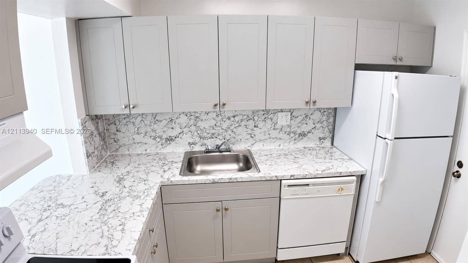 11150 SW 196th Street, #D211, Cutler Bay, Cutler Bay, FL 33157 Kitchen featuring shaker-style cabinetry, patterned stone-look countertops, matching full-height backsplash, stainless steel drop-in sink, and a built-in dishwasher