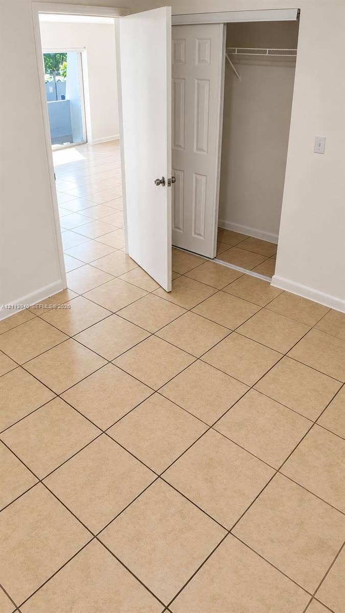 11150 SW 196th Street, #D211, Cutler Bay, Cutler Bay, FL 33157 Room featuring neutral tile flooring, a closet with sliding panel doors, and a swinging interior door