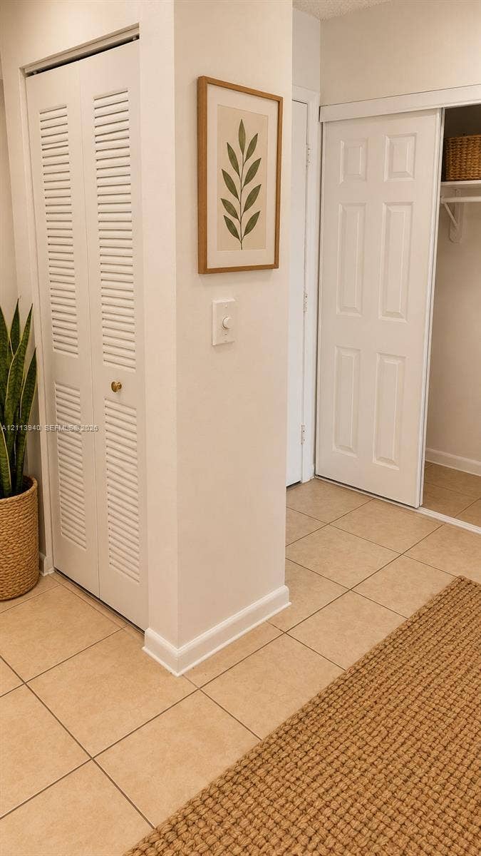 11150 SW 196th Street, #D211, Cutler Bay, Cutler Bay, FL 33157 Ceramic tile flooring, bi-fold louvered closet doors, and a sliding closet door with built-in shelving