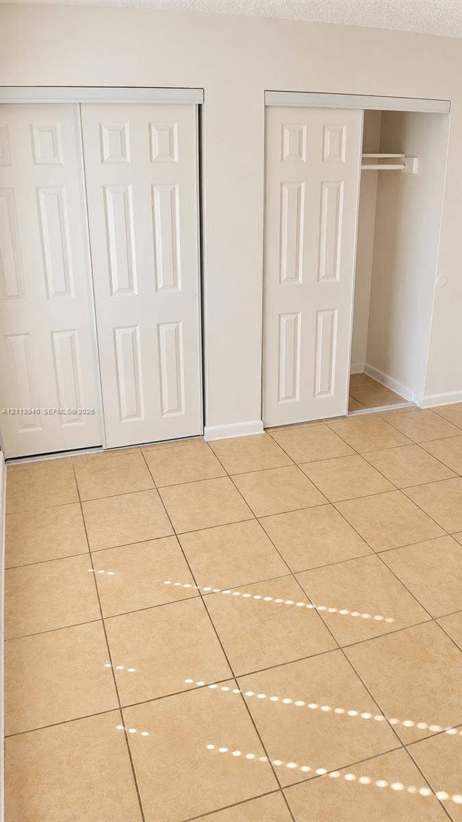 11150 SW 196th Street, #D211, Cutler Bay, Cutler Bay, FL 33157 Neutral-toned ceramic tile flooring, two closets with six-panel sliding doors, and built-in closet shelving