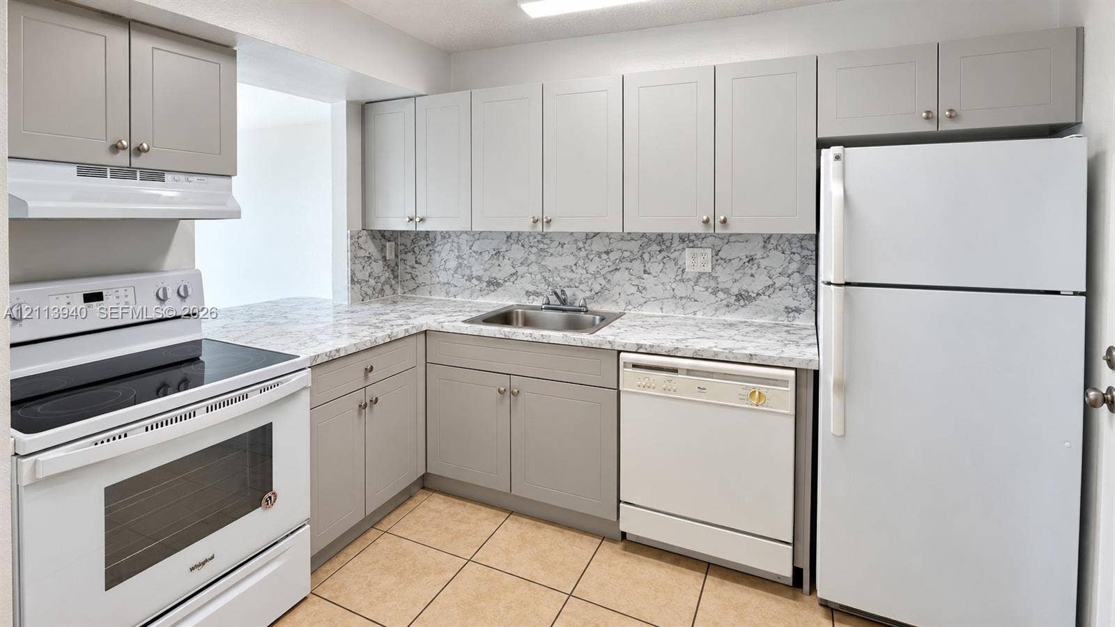 11150 SW 196th Street, #D211, Cutler Bay, Cutler Bay, FL 33157 Kitchen featuring light gray shaker-style cabinetry, stone-patterned laminate countertops, tile flooring, and white built-in appliances including a range, dishwasher, and refrigerator