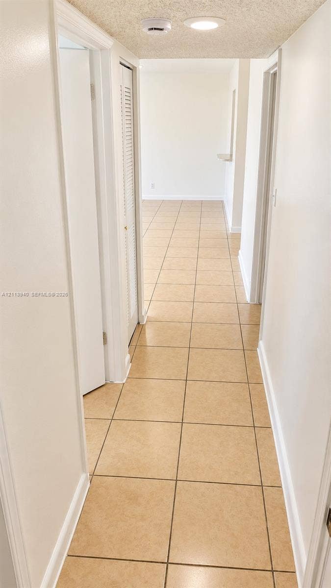 11150 SW 196th Street, #D211, Cutler Bay, Cutler Bay, FL 33157 Hallway featuring neutral ceramic tile flooring, recessed lighting, and louvered closet doors