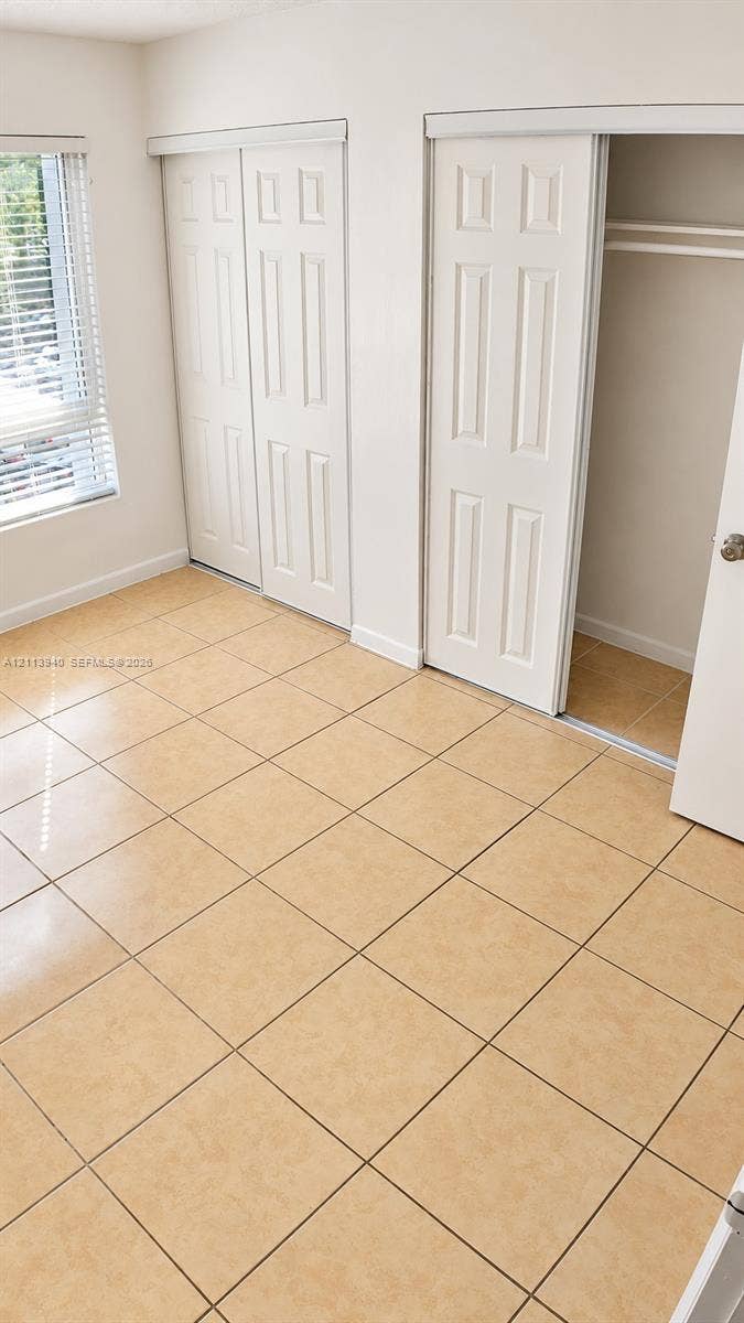 11150 SW 196th Street, #D211, Cutler Bay, Cutler Bay, FL 33157 Ceramic tile flooring, multi-panel sliding closet doors, and horizontal slat window blinds