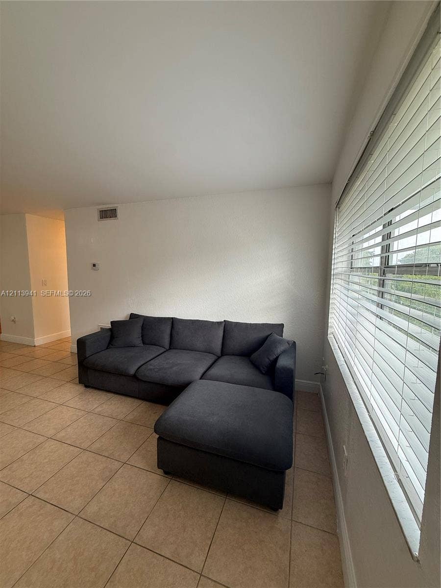 17255 SW 95th Avenue, #457, Palmetto Bay, Palmetto Bay, FL 33157 Ceramic tile flooring, neutral wall finishes, and expansive windows featuring horizontal slat blinds