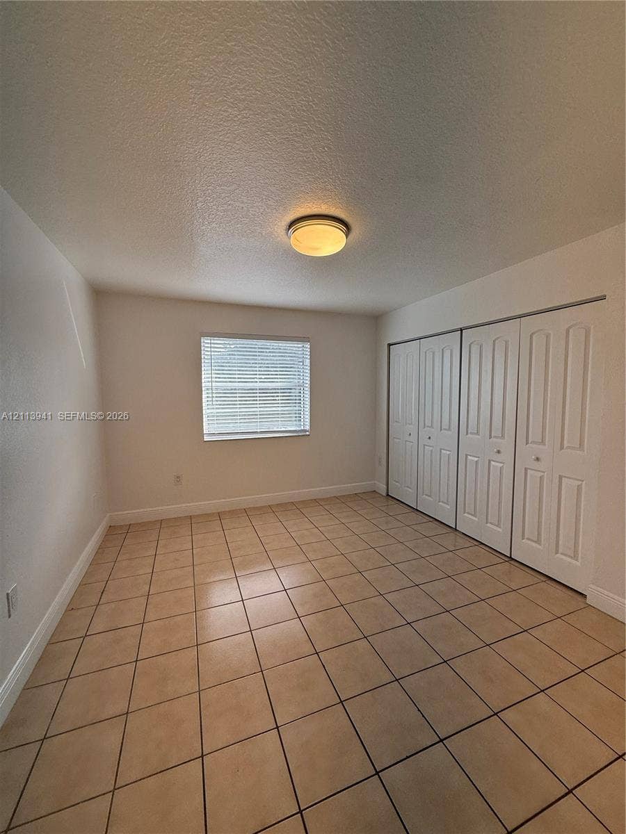 17255 SW 95th Avenue, #457, Palmetto Bay, Palmetto Bay, FL 33157 Neutral-toned tile flooring, multi-panel closet doors, and flush-mount ceiling lighting
