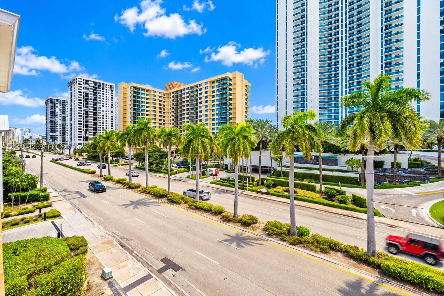 2710 S Ocean Drive, #401, Hollywood, FL 33019 High-rise urban streetscape featuring palm-lined boulevards, meticulously manicured landscaping, and contemporary multi-story residential architecture