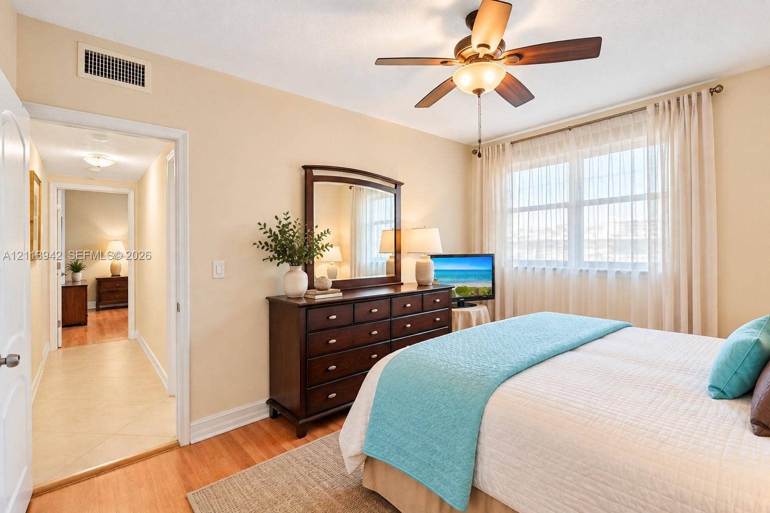 2710 S Ocean Drive, #401, Hollywood, FL 33019 Room featuring wood-finish flooring, a multi-blade ceiling fan with integrated lighting, and a large window with horizontal blinds