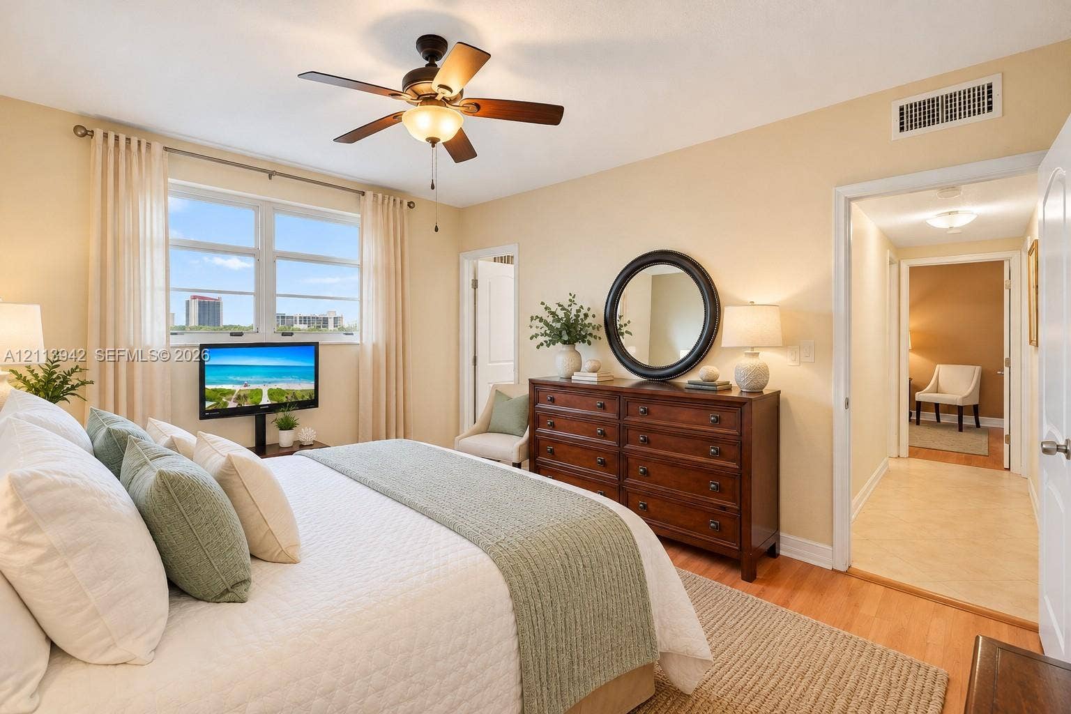 2710 S Ocean Drive, #401, Hollywood, FL 33019 Bedroom featuring wood-finish flooring, a ceiling fan with integrated lighting, and dual-pane windows