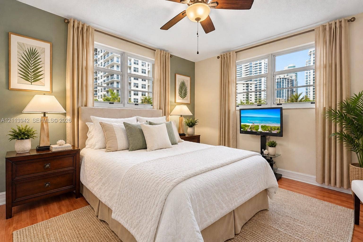 2710 S Ocean Drive, #401, Hollywood, FL 33019 Bedroom featuring wood-finish flooring, dual-aspect windows, and a ceiling fan with integrated lighting
