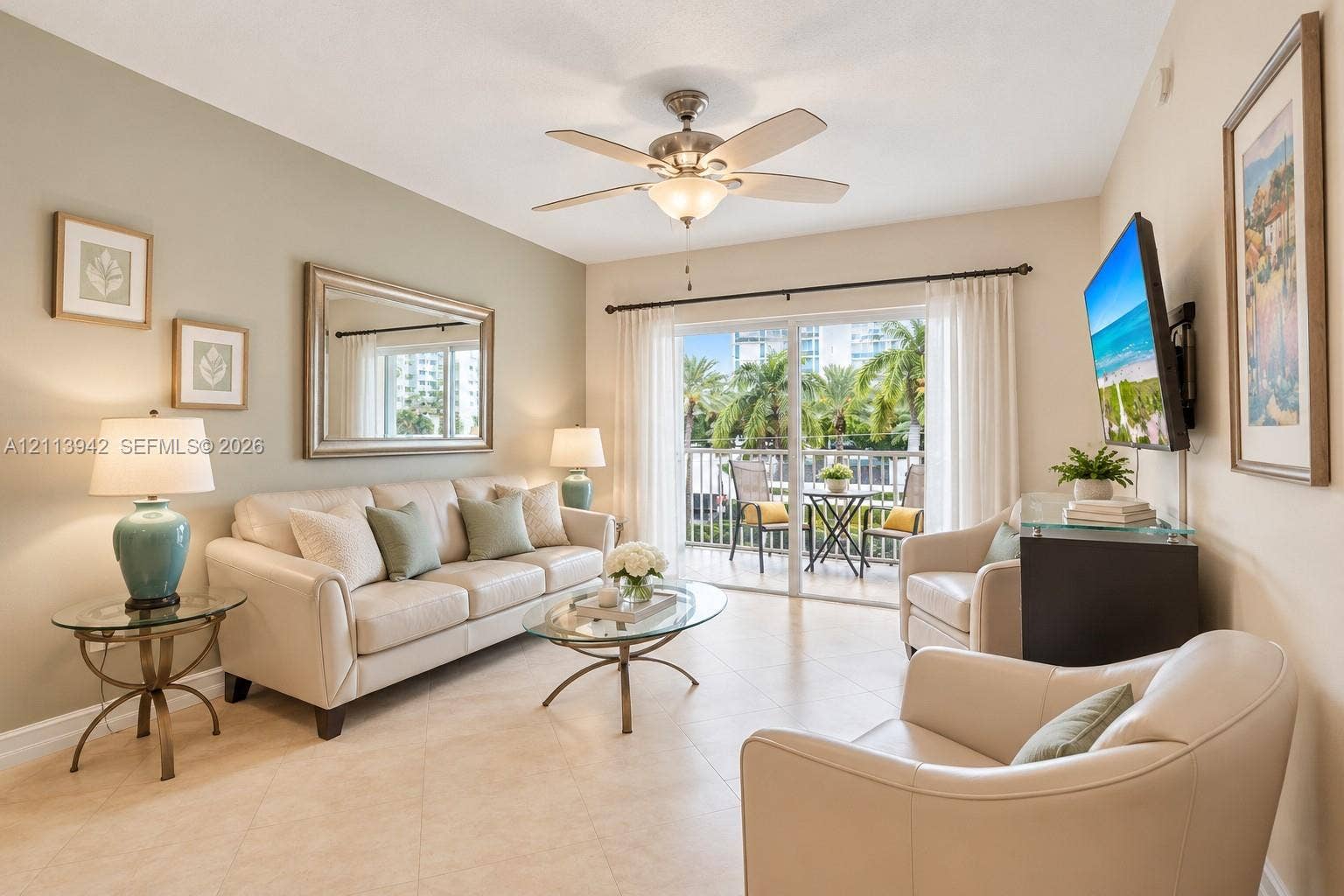 2710 S Ocean Drive, #401, Hollywood, FL 33019 Living area featuring tile flooring, vaulted ceilings, a central ceiling fan, and sliding glass doors leading to a balcony