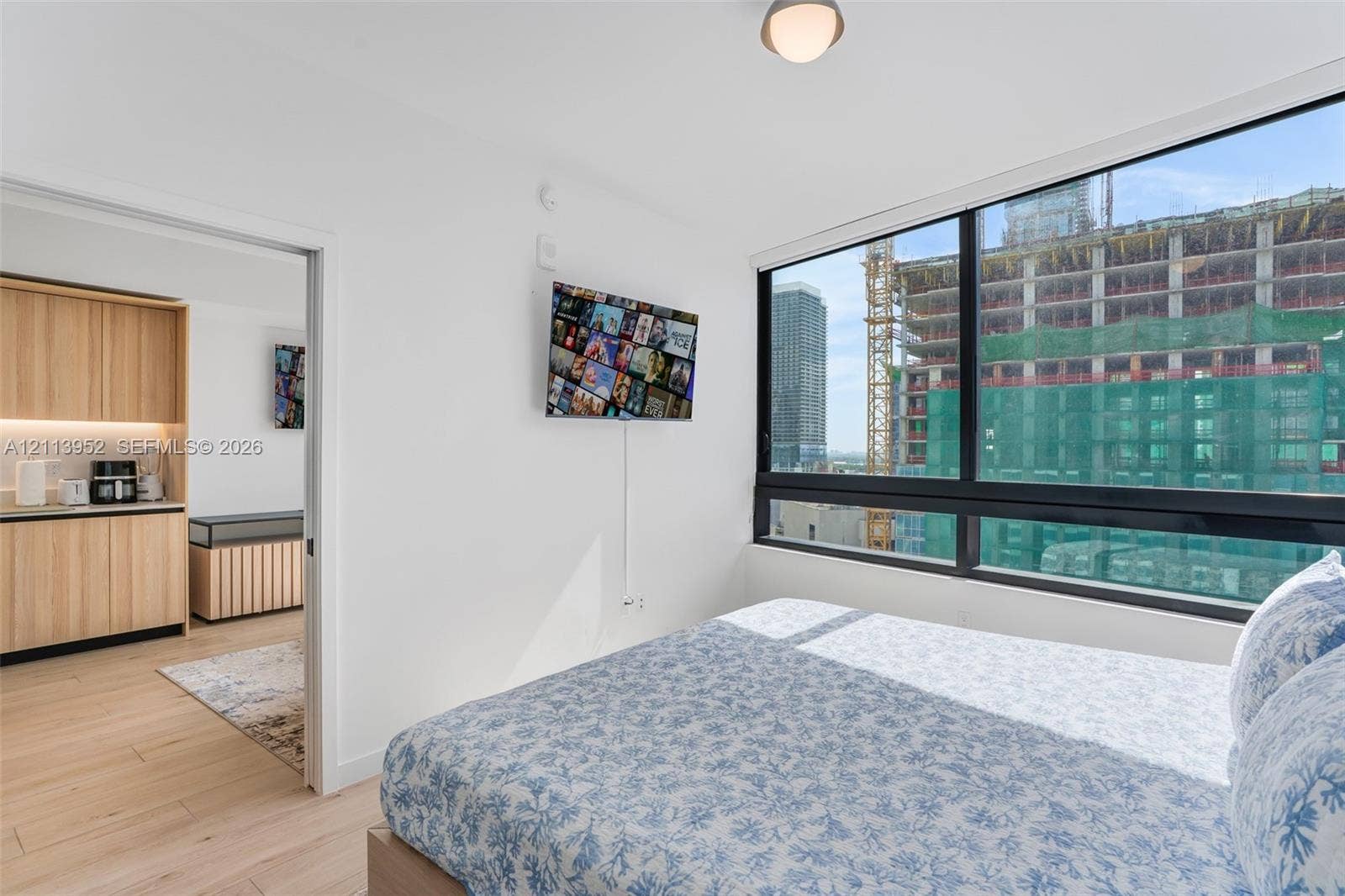 Floor-to-ceiling windows, wood-finish flooring, and recessed ceiling lighting