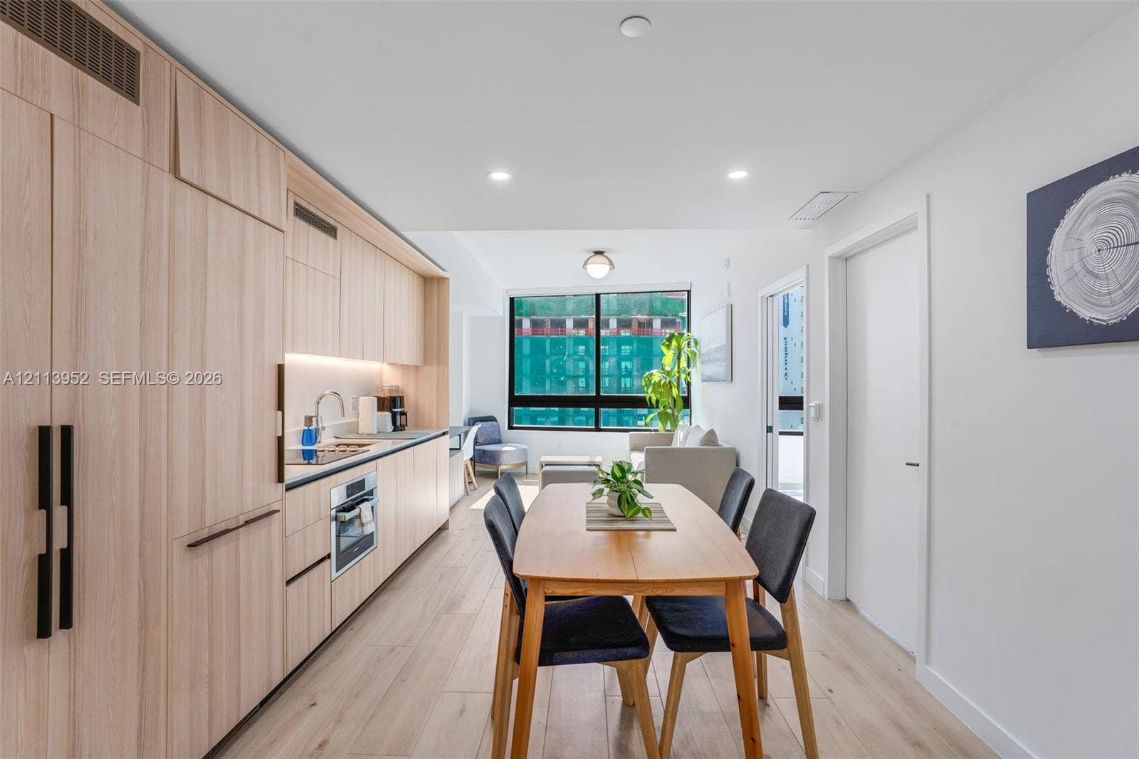 Kitchen featuring light wood-finish cabinetry, built-in appliances, recessed lighting, and wood-finish flooring