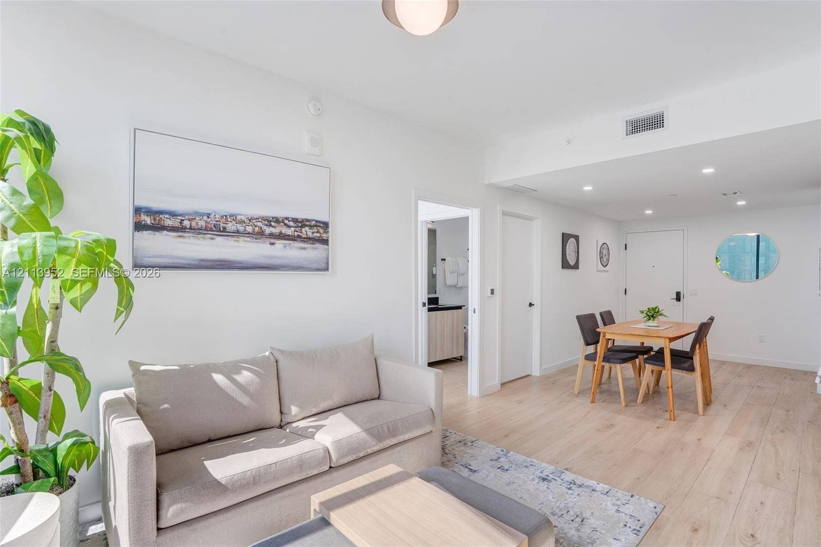 Open-concept interior featuring light wood-finish flooring, recessed lighting, and a neutral color palette