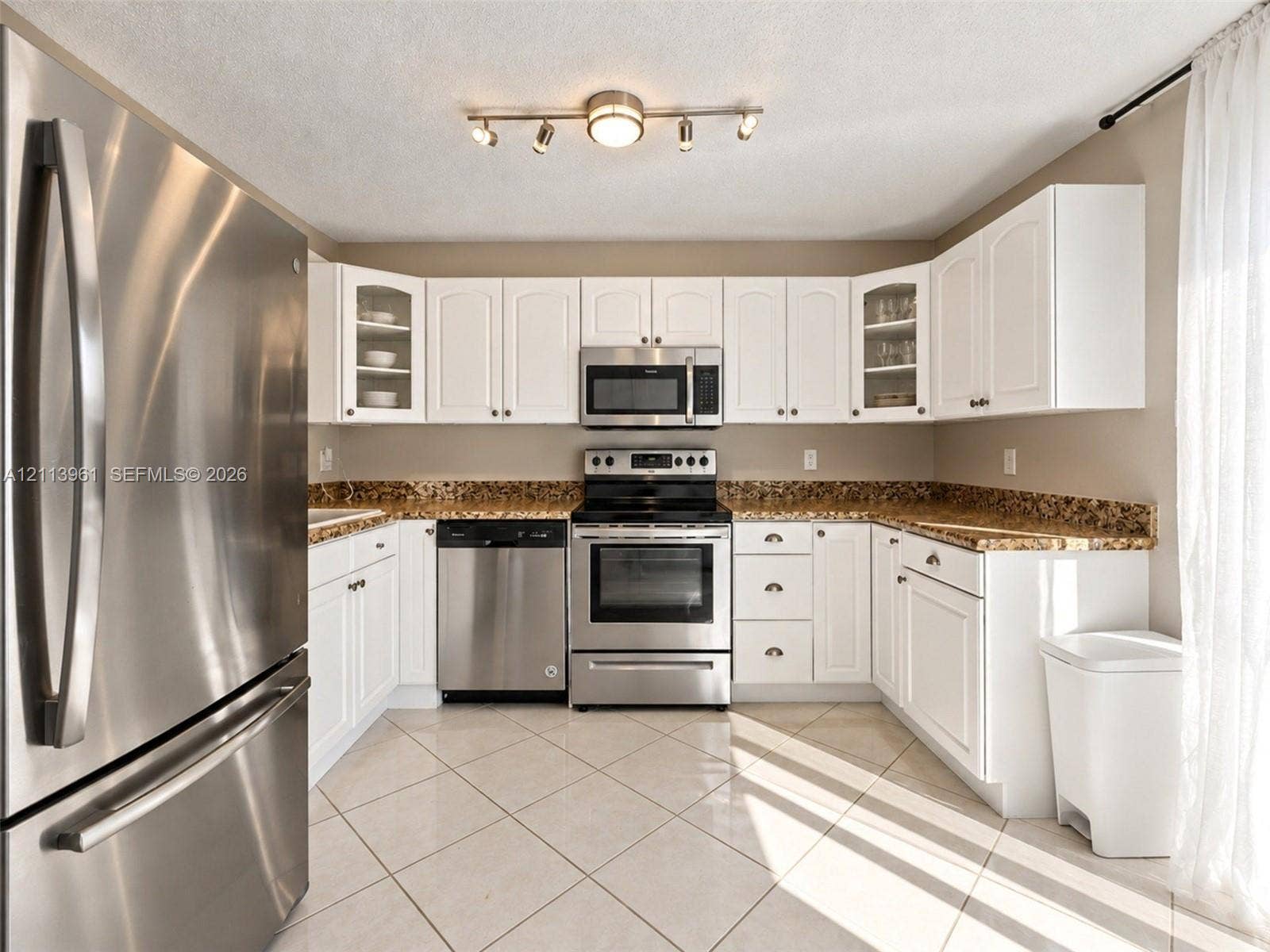 339 City View Drive, #339, Fort Lauderdale, Fort Lauderdale, FL 33311 Kitchen featuring white cabinetry, stone-finish countertops, stainless steel appliances, ceramic tile flooring, and multi-directional track lighting