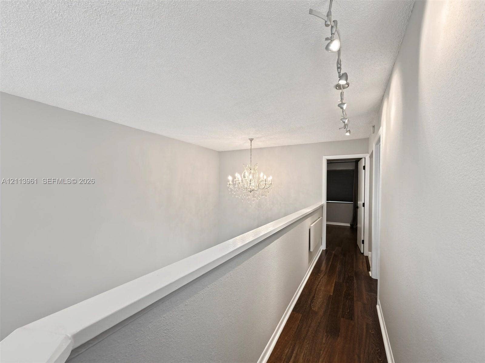 339 City View Drive, #339, Fort Lauderdale, Fort Lauderdale, FL 33311 Hallway featuring dark wood-finish flooring, a multi-light crystal chandelier, and track lighting