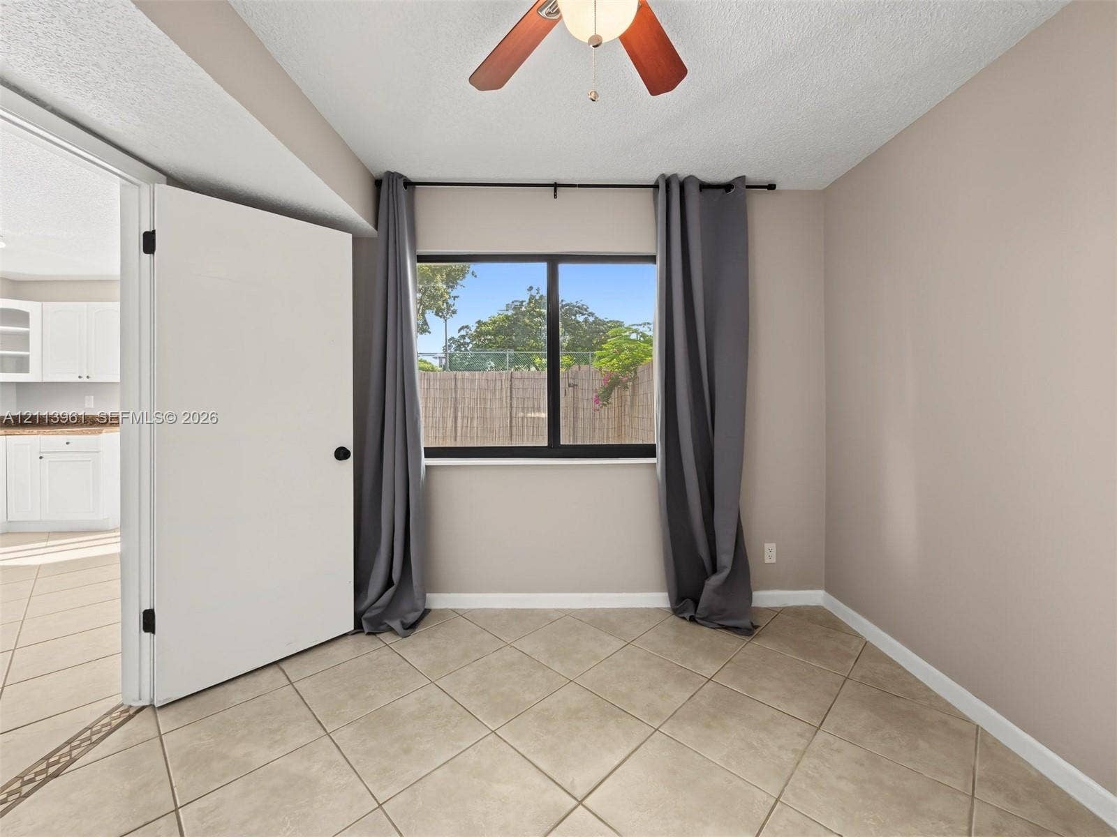 339 City View Drive, #339, Fort Lauderdale, Fort Lauderdale, FL 33311 Interior space featuring neutral-toned walls, tile flooring, a window with a black frame, and an overhead ceiling fan with integrated lighting