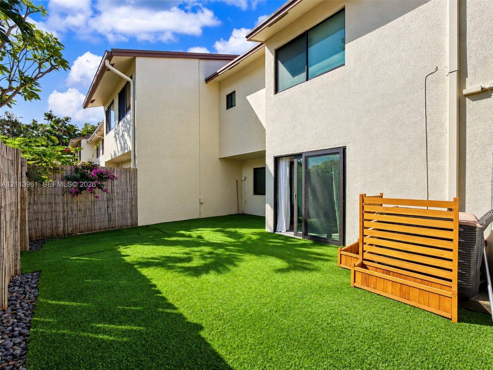 339 City View Drive, #339, Fort Lauderdale, Fort Lauderdale, FL 33311 Private outdoor space featuring artificial turf, perimeter bamboo fencing, river rock border, and a wood privacy screen