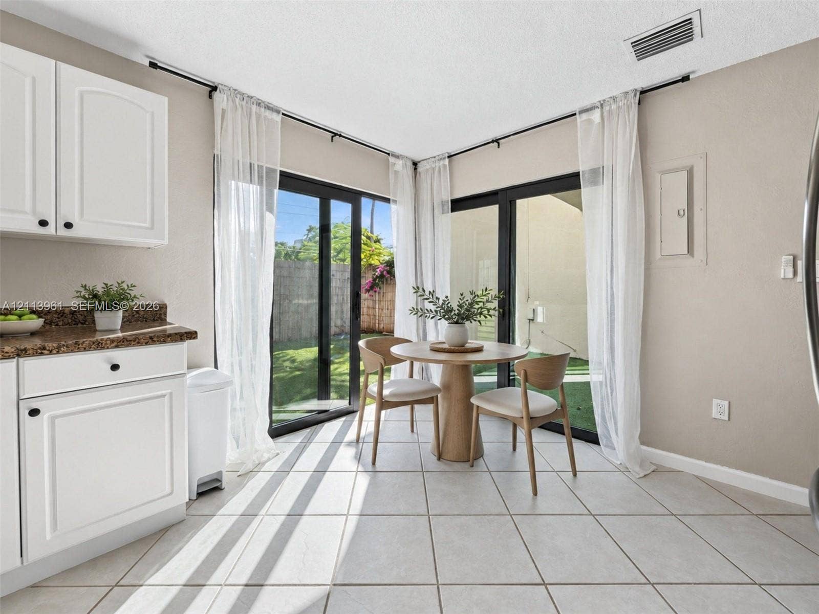 339 City View Drive, #339, Fort Lauderdale, Fort Lauderdale, FL 33311 White cabinetry, stone-finish countertops, tile flooring, and floor-to-ceiling sliding glass doors