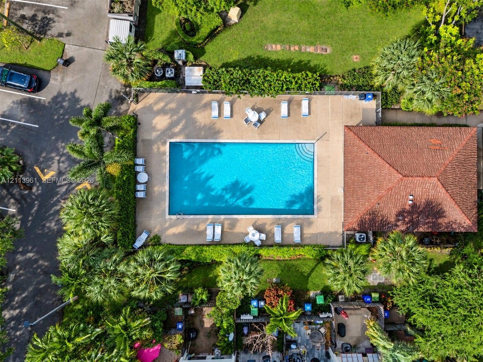 339 City View Drive, #339, Fort Lauderdale, Fort Lauderdale, FL 33311 Rectangular swimming pool with surrounding concrete deck, terracotta-tiled roof structure, and perimeter landscaping featuring mature trees