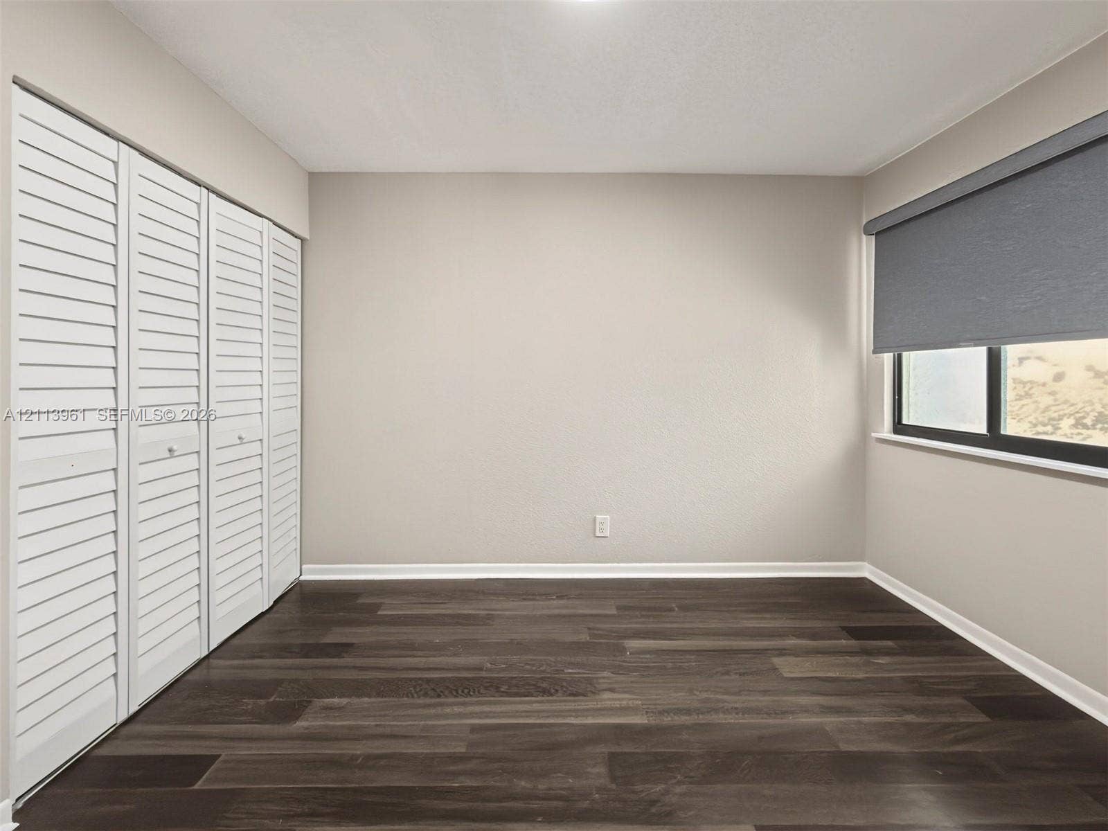 339 City View Drive, #339, Fort Lauderdale, Fort Lauderdale, FL 33311 Neutral-toned walls, wood-finish flooring, and white louvered-style closet doors