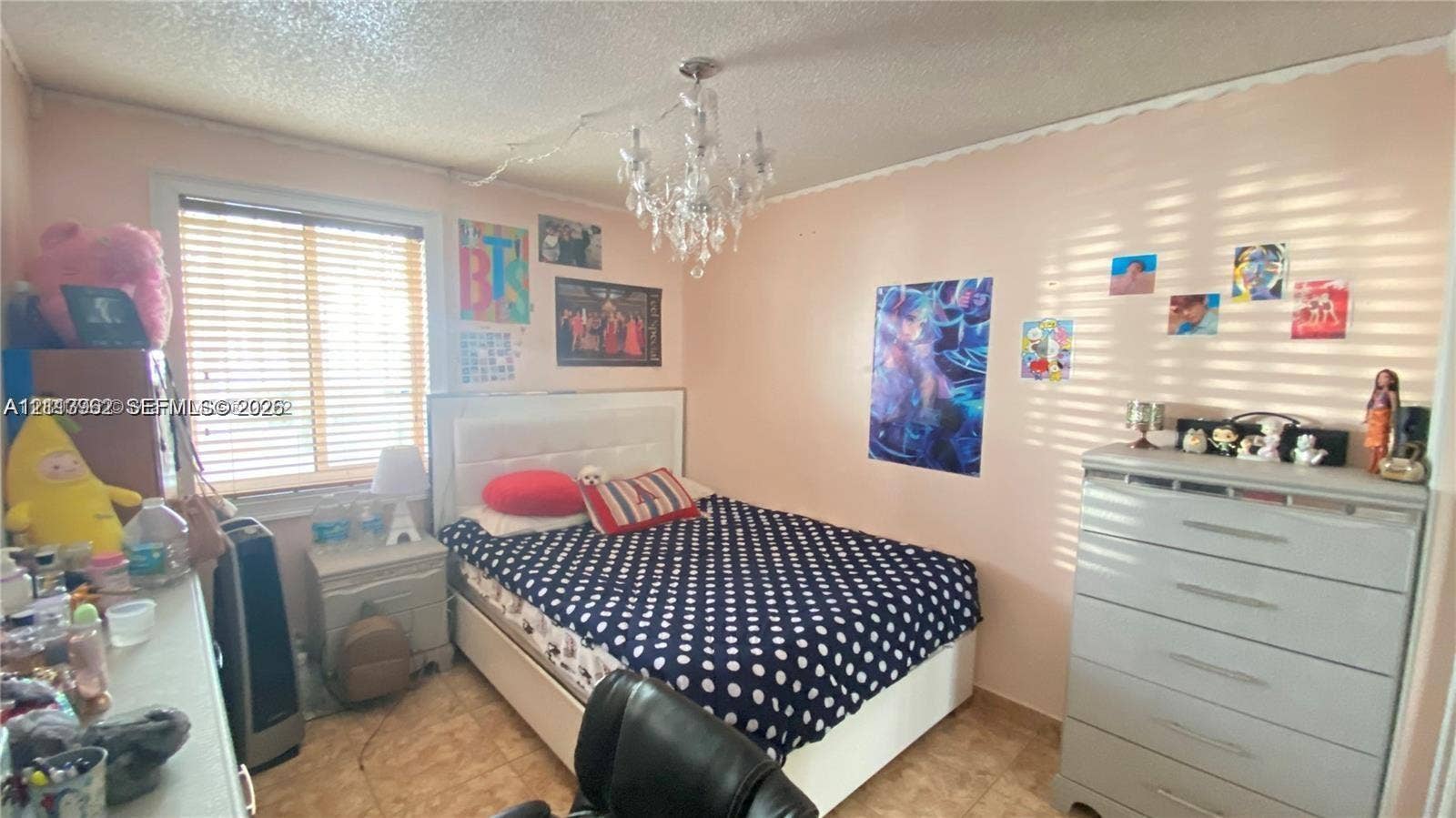 19764 NW 54 Avenue, Miami Gardens, FL 33055 Room featuring horizontal blinds, tile flooring, and a central crystal-style chandelier fixture