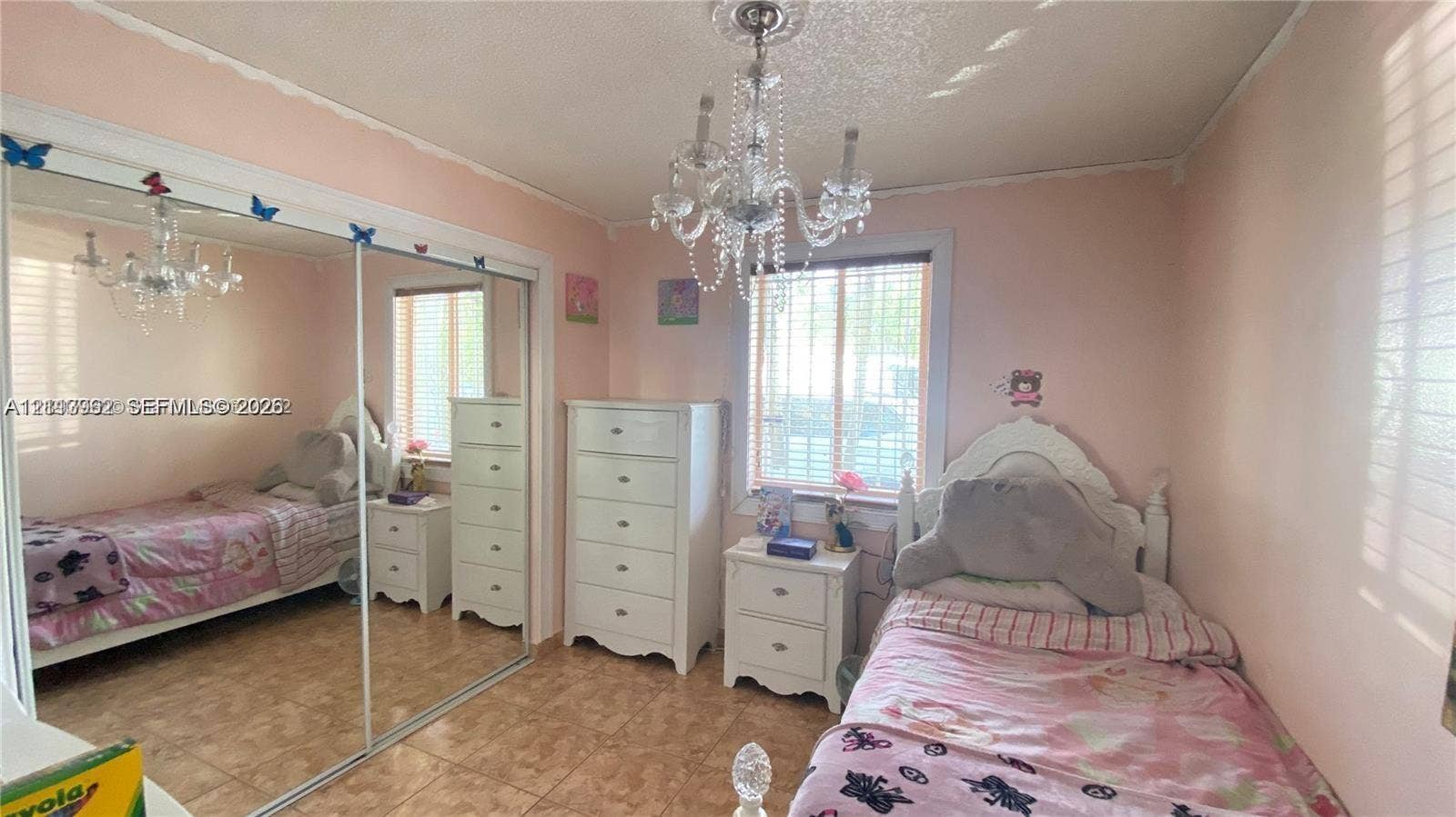 19764 NW 54 Avenue, Miami Gardens, FL 33055 Room interior featuring tile flooring, a large sliding glass-door closet, and an ornate crystal-style chandelier