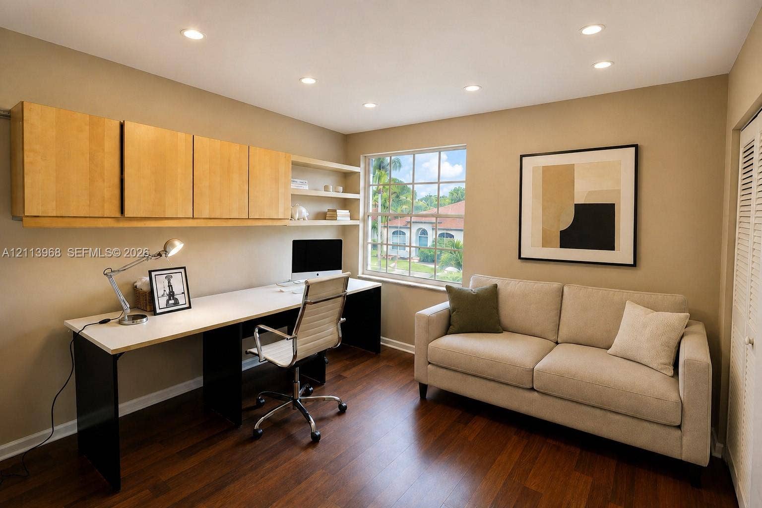 Built-in wood-finish cabinetry, integrated open shelving, expansive desk surface, wood-finish flooring, and recessed ceiling lighting