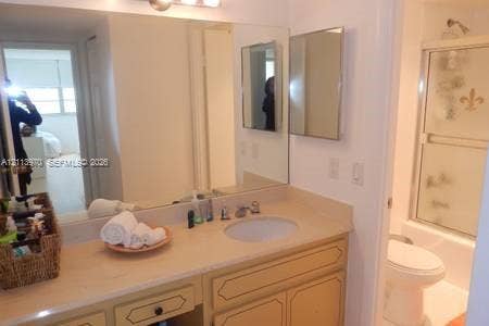 1904 S Ocean Drive, #1001, Hallandale Beach, Hallandale Beach, FL 33009 Bathroom featuring a vanity with a solid-surface countertop, recessed oval sink, full-width wall mirror, and a tub-shower combination with sliding glass doors