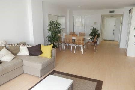 1904 S Ocean Drive, #1001, Hallandale Beach, Hallandale Beach, FL 33009 Open floor plan featuring light-toned wood-finish flooring, a wall-mounted mirror, and a neutral color palette