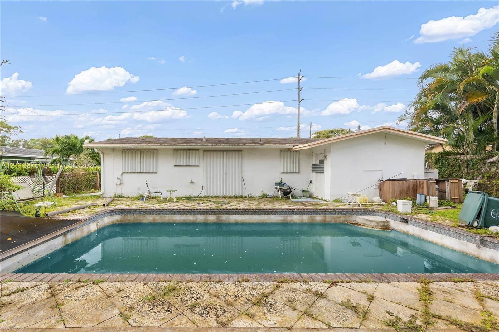 3740 NE 6th Avenue, Oakland Park, FL 33334 In-ground swimming pool with a stone paver patio