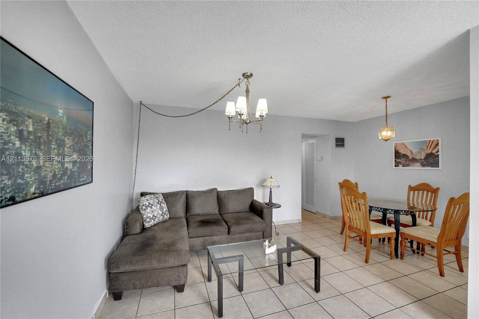 2145 Pierce Street, #416, Hollywood, FL 33020 Living area featuring tile flooring, neutral wall paint, and two overhead multi-light chandeliers