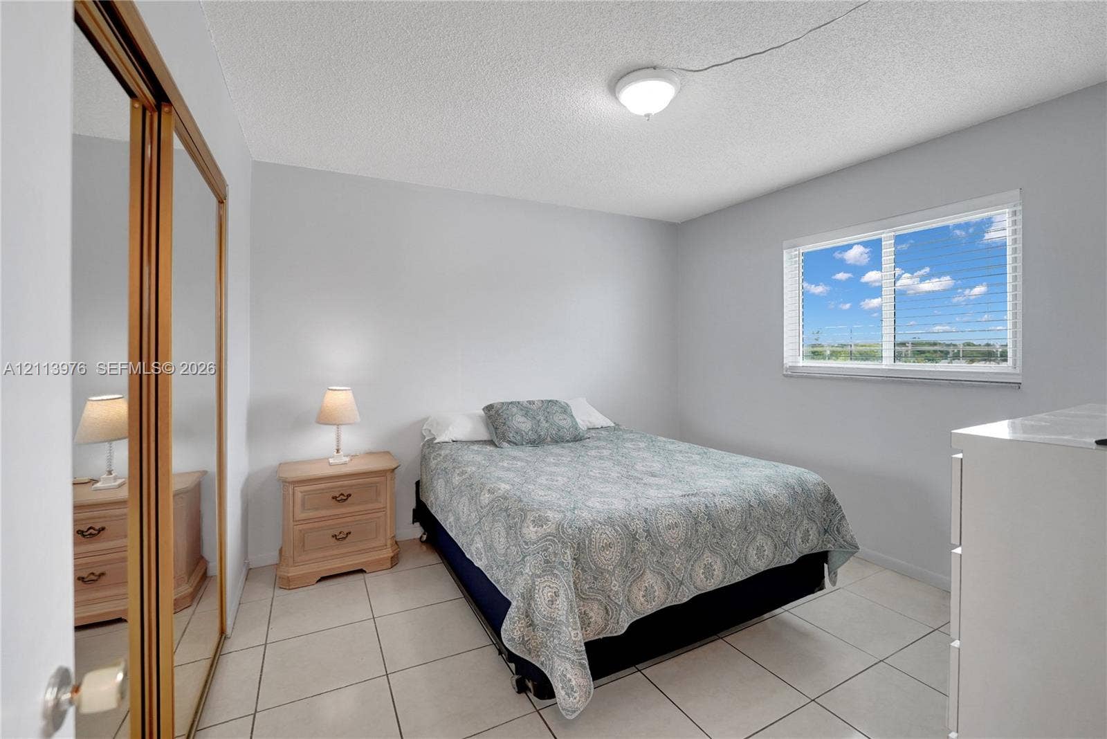 2145 Pierce Street, #416, Hollywood, FL 33020 Neutral wall finishes, large-format tile flooring, sliding mirror-panel closet doors, and a horizontal sliding window