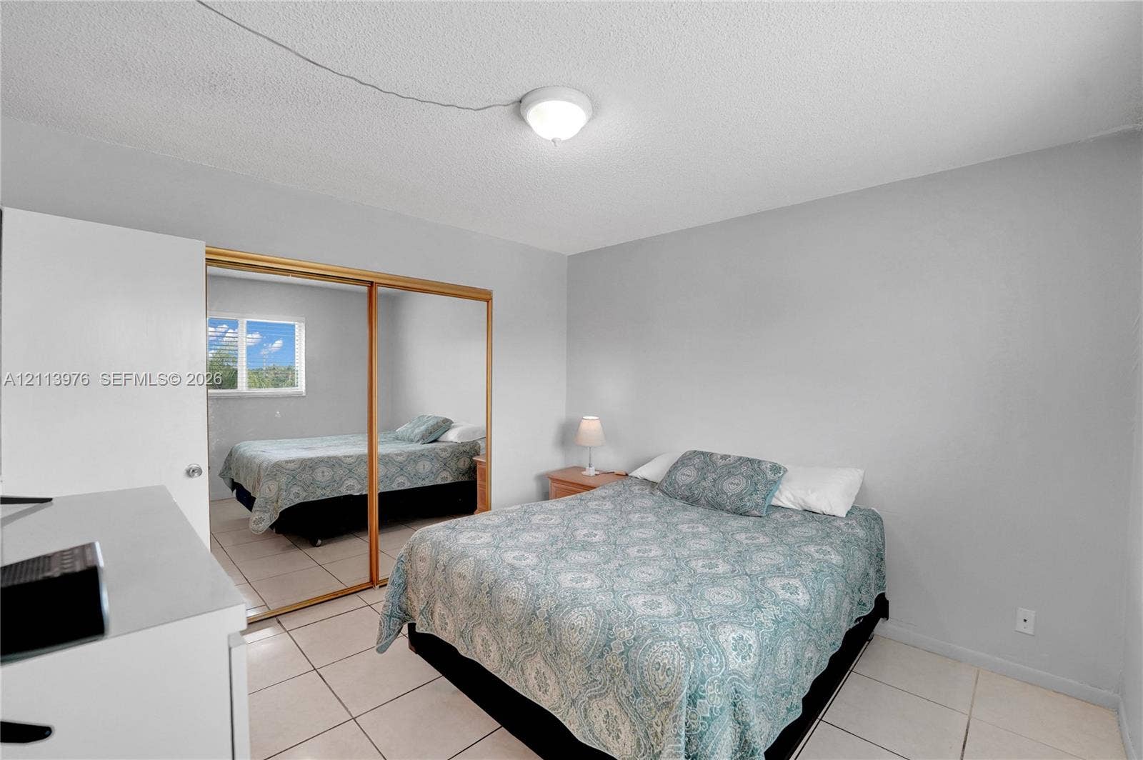 2145 Pierce Street, #416, Hollywood, FL 33020 Bedroom featuring neutral wall paint, tile flooring, and a mirrored sliding closet door