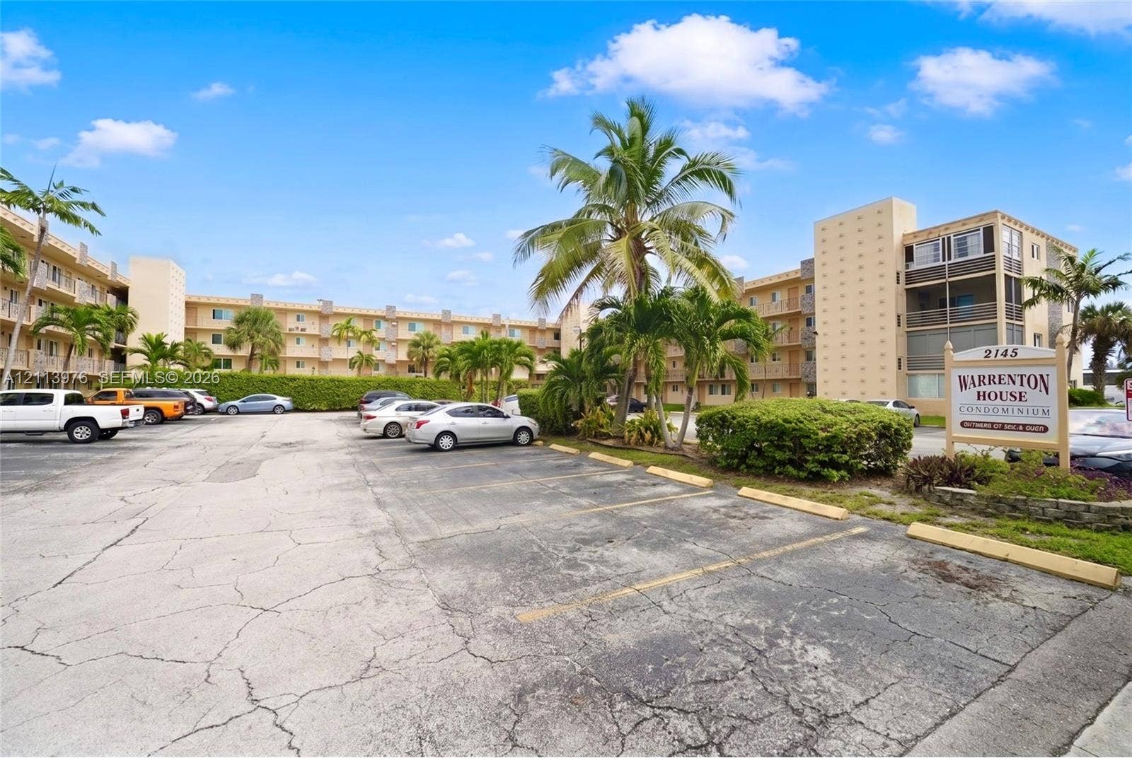 2145 Pierce Street, #416, Hollywood, FL 33020 Multi-story residential complex featuring stucco exterior walls, private balconies, and mature palm tree landscaping