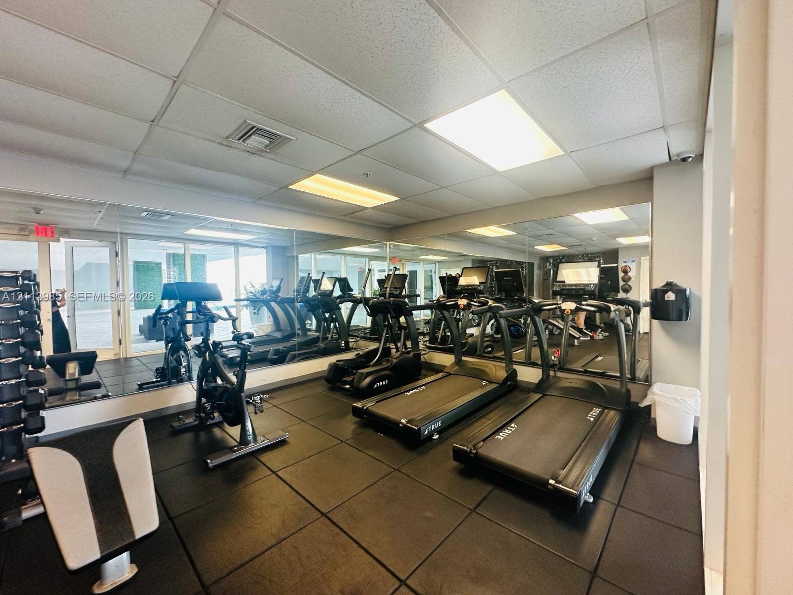 170 SE 14th Street, #2203, Miami, Miami, FL 33131 Fitness area featuring rubberized flooring, expansive wall-to-wall mirrors, recessed drop-ceiling lighting, and glass paneled doors